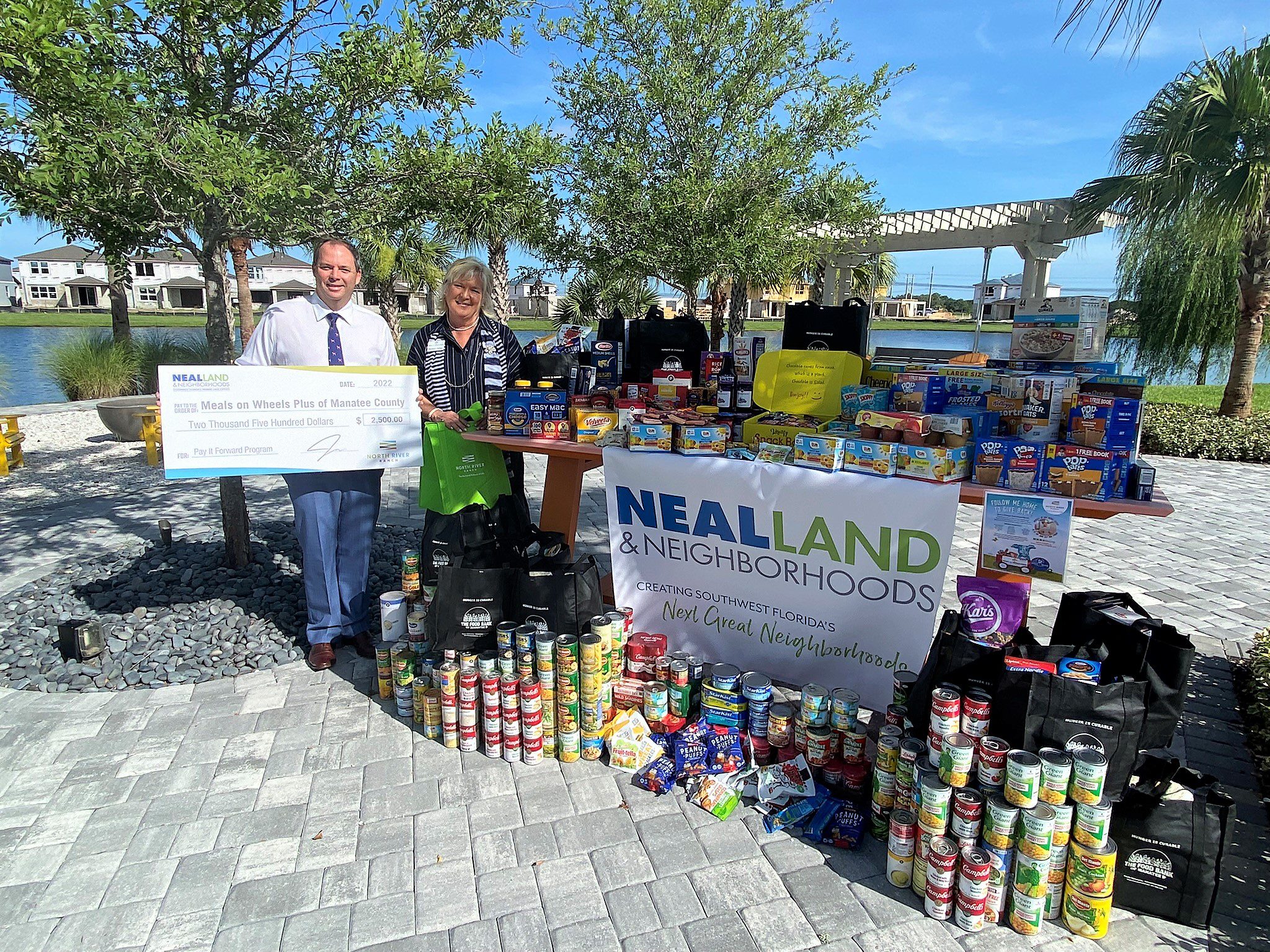 Food drive and check presentation Neal Land and Meals on Wheels